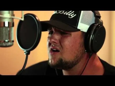 Singer Landon Shill recording vocals through a pop filter at Hit Warehouse Recording Studios