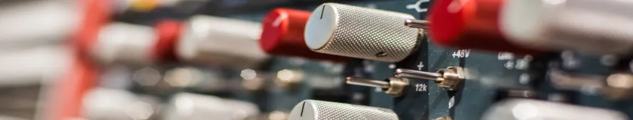 Close-up of microphone preamp controls and phantom-power switches in the Hit Warehouse studio rack