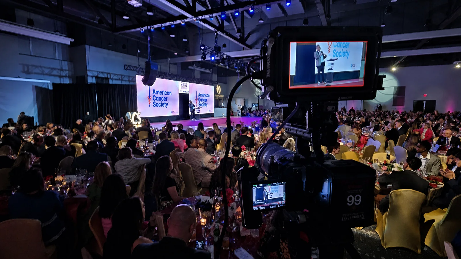 Live multicamera production at an American Cancer Society event with the stage framed through a production monitor